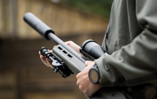 Close-up of a person holding a rifle.