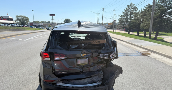 Rear view of a black Chevrolet Equinox with crushed rear hatch and bumper damage after a chain-reaction crash.