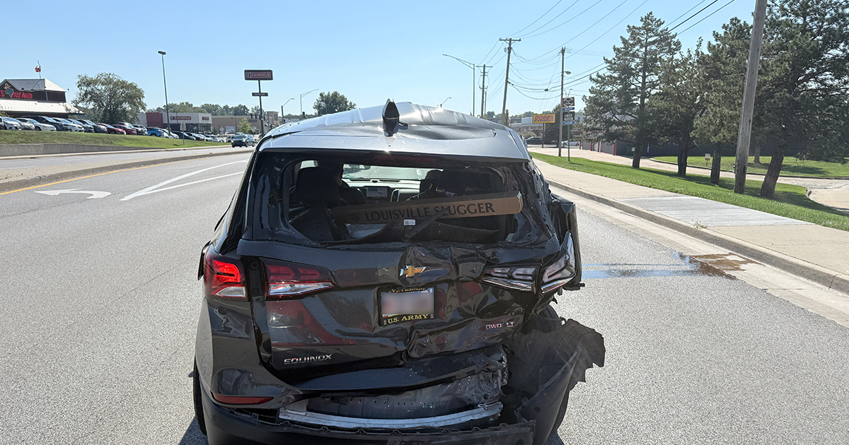 Rear view of a black Chevrolet Equinox with crushed rear hatch and bumper damage after a chain-reaction crash.